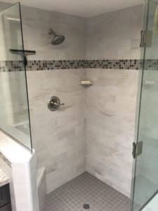 Open shower with grey and white tile. 