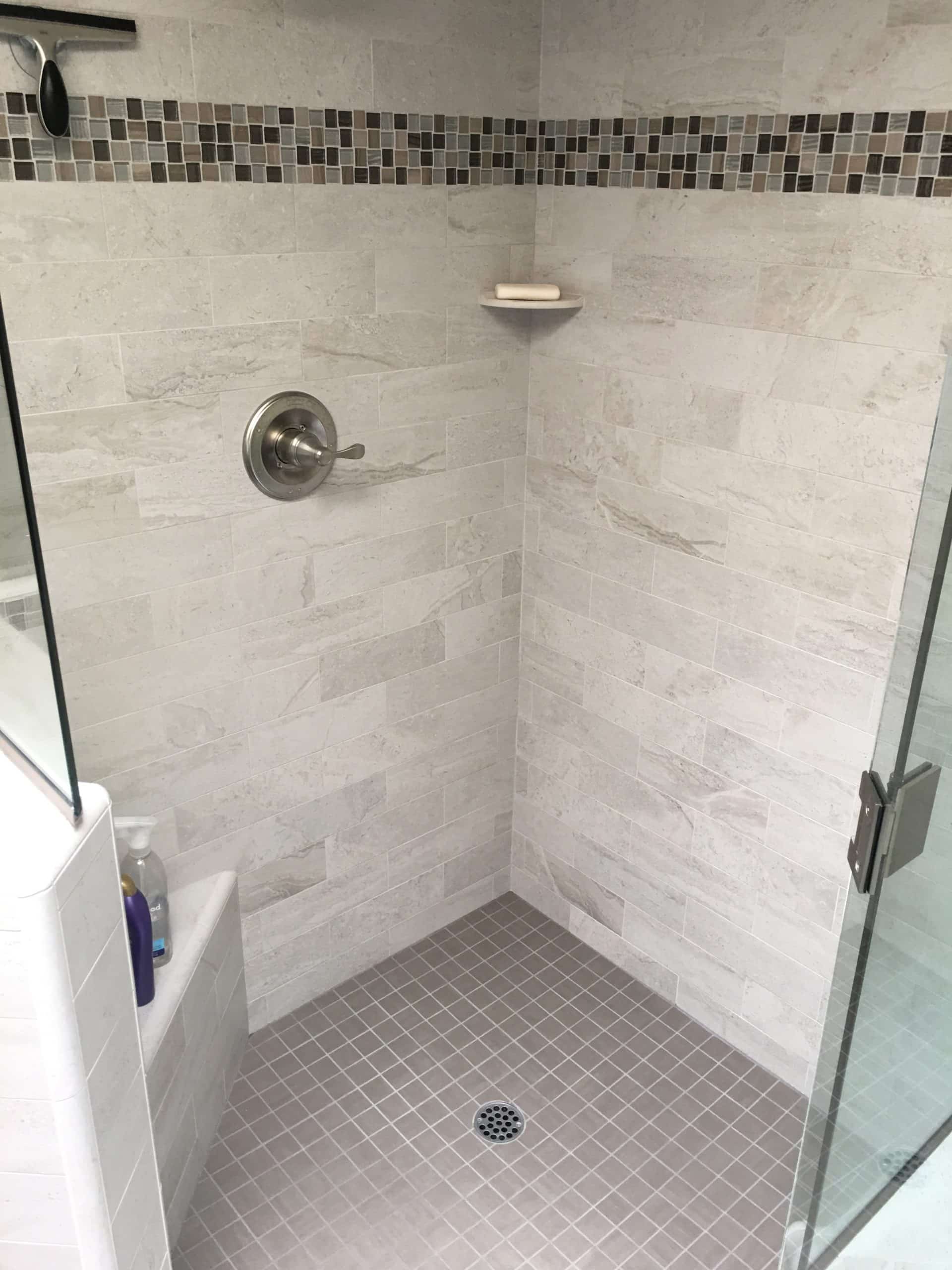 This image features a walk-in shower with grey tile.